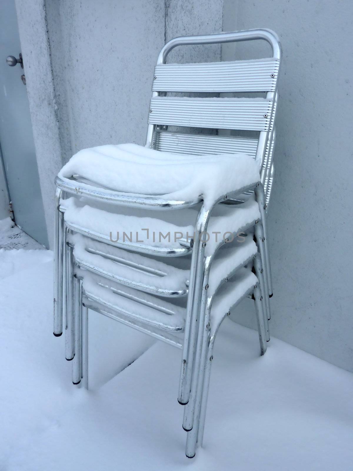 Pile of chairs covered by snow by Elenaphotos21