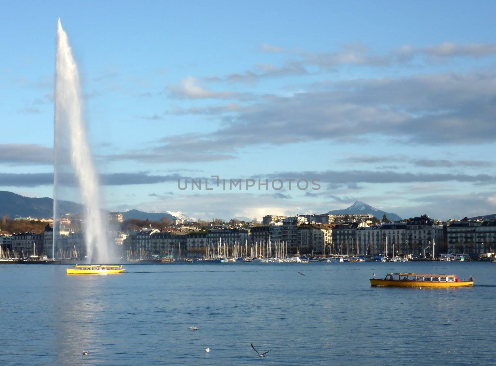 View of the fountain of Geneva lake with a small yellow boat aside