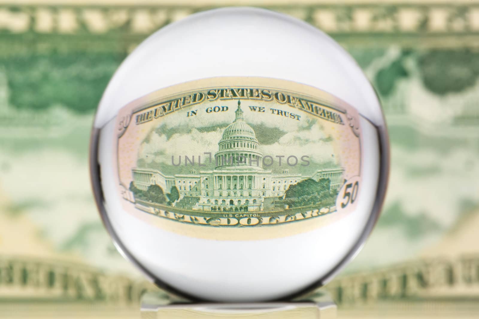 Fifty dollar banknote through glass sphere. Blur background.