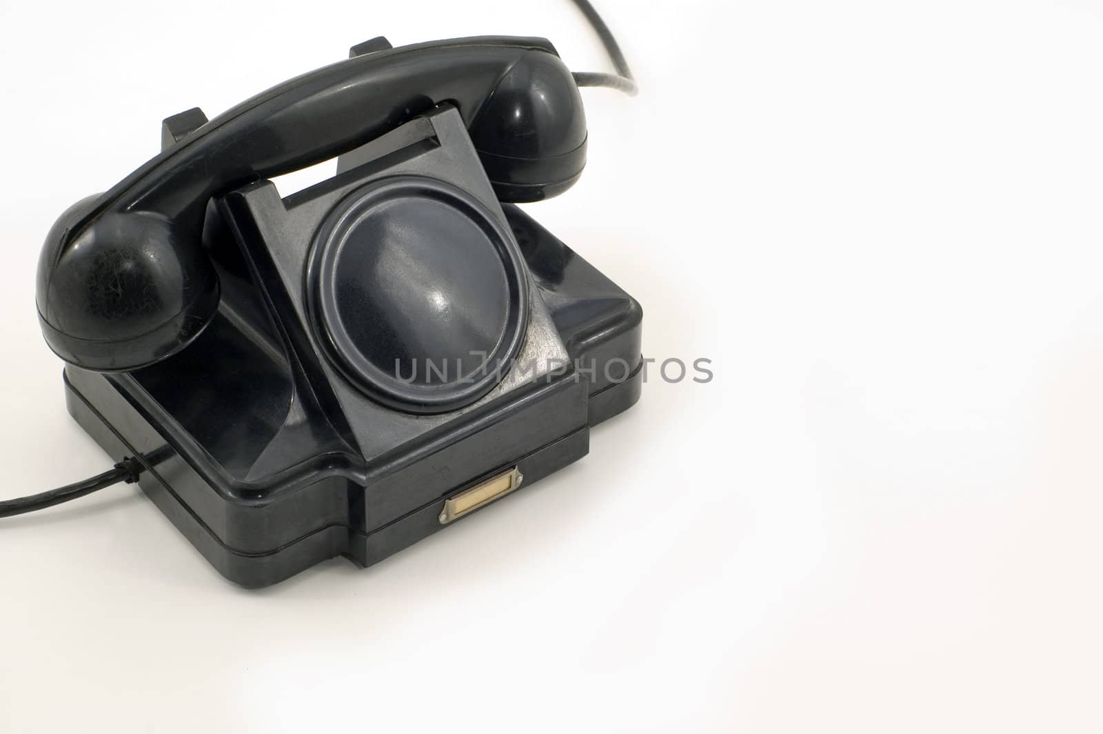 The old telephone of black colour on a white background.