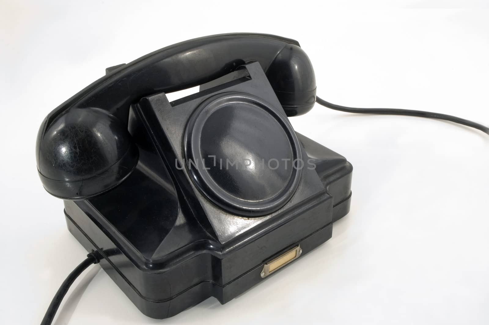 The old telephone of black colour on a white background.