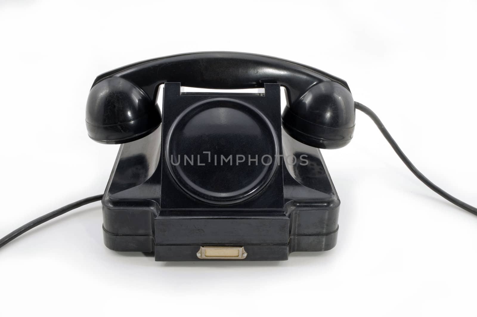 Old-fashioned black telephone receiver with cord on white background.