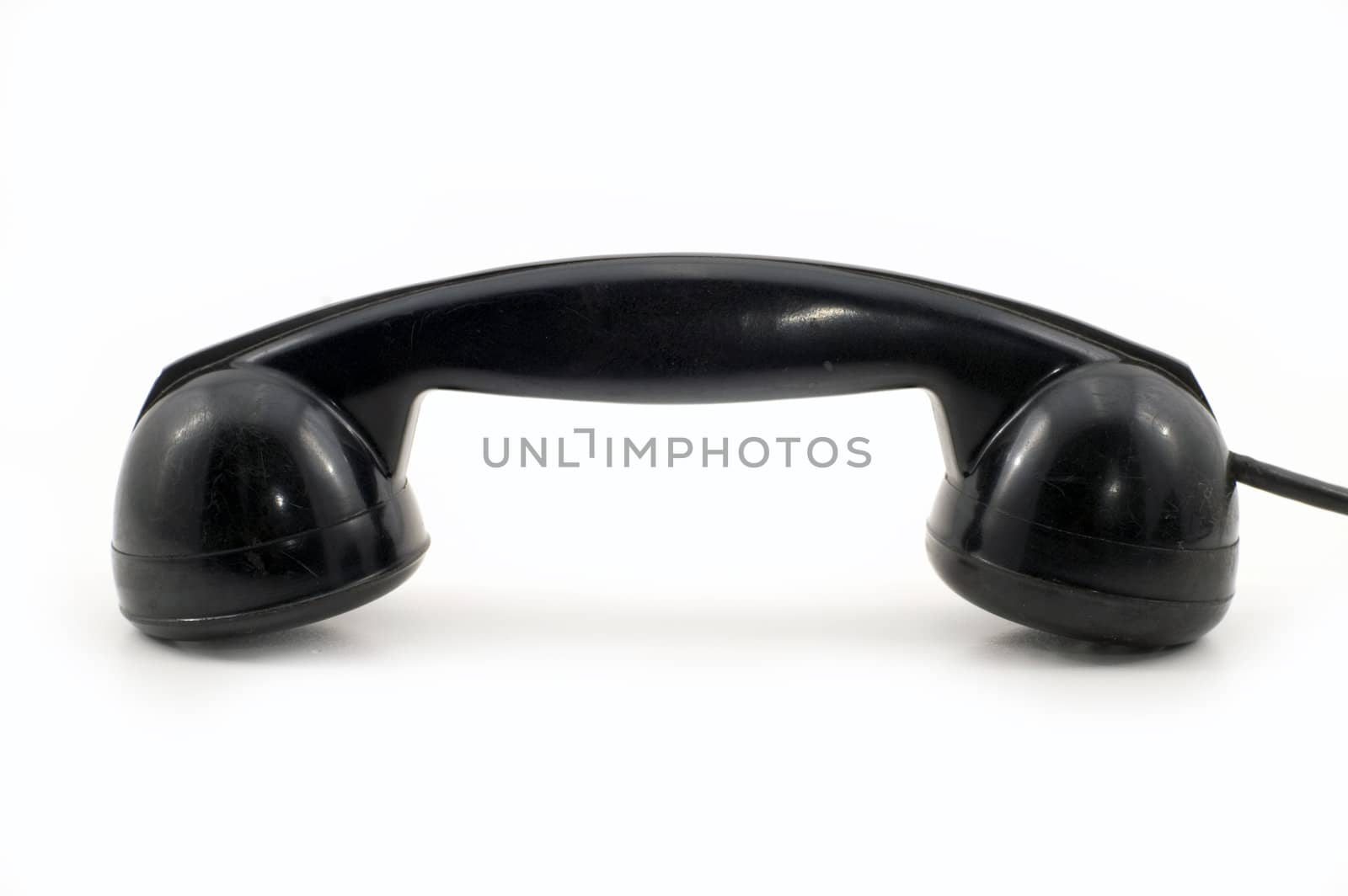 The old telephone of black colour on a white background.