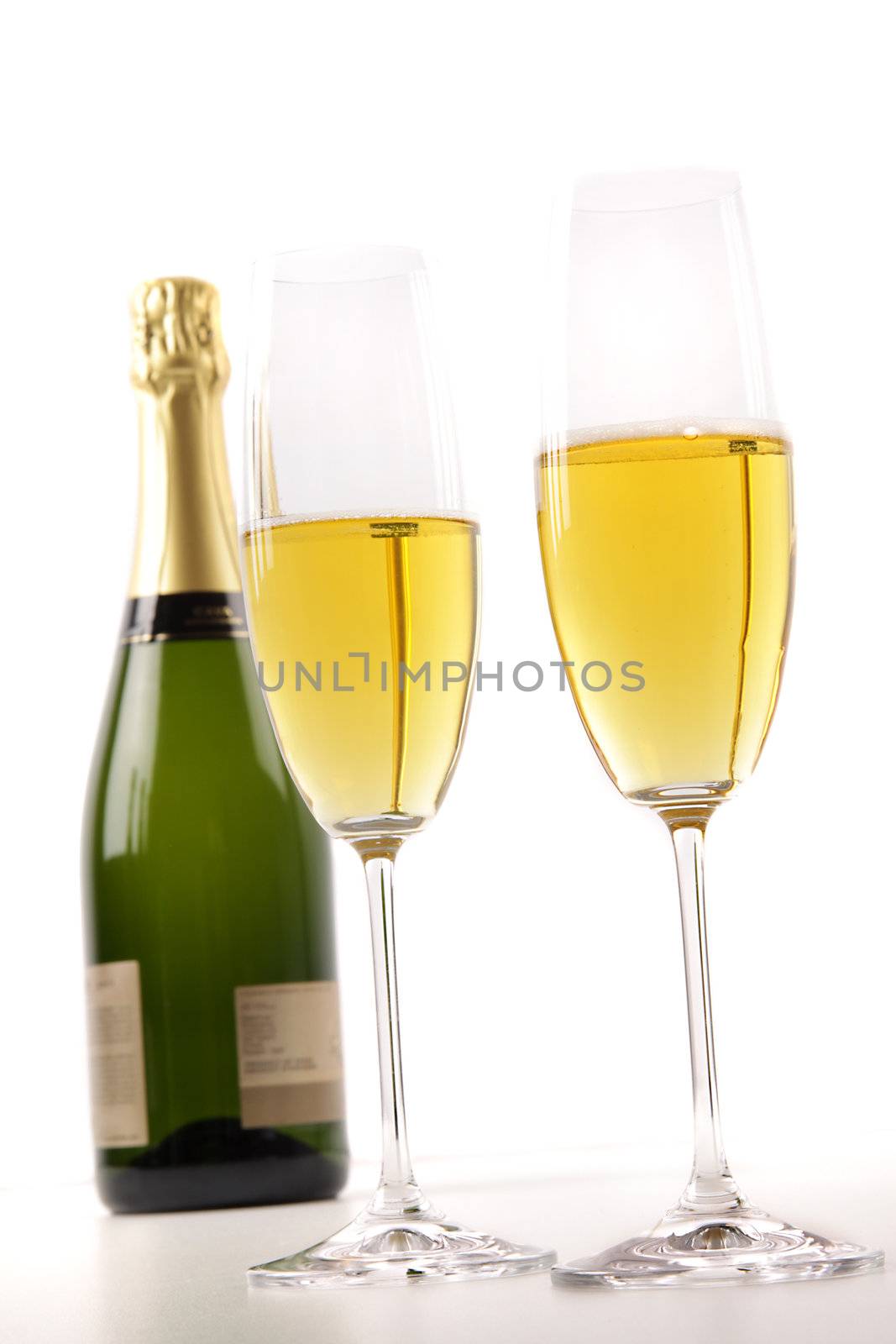 Champagne glasses with bottle on white background