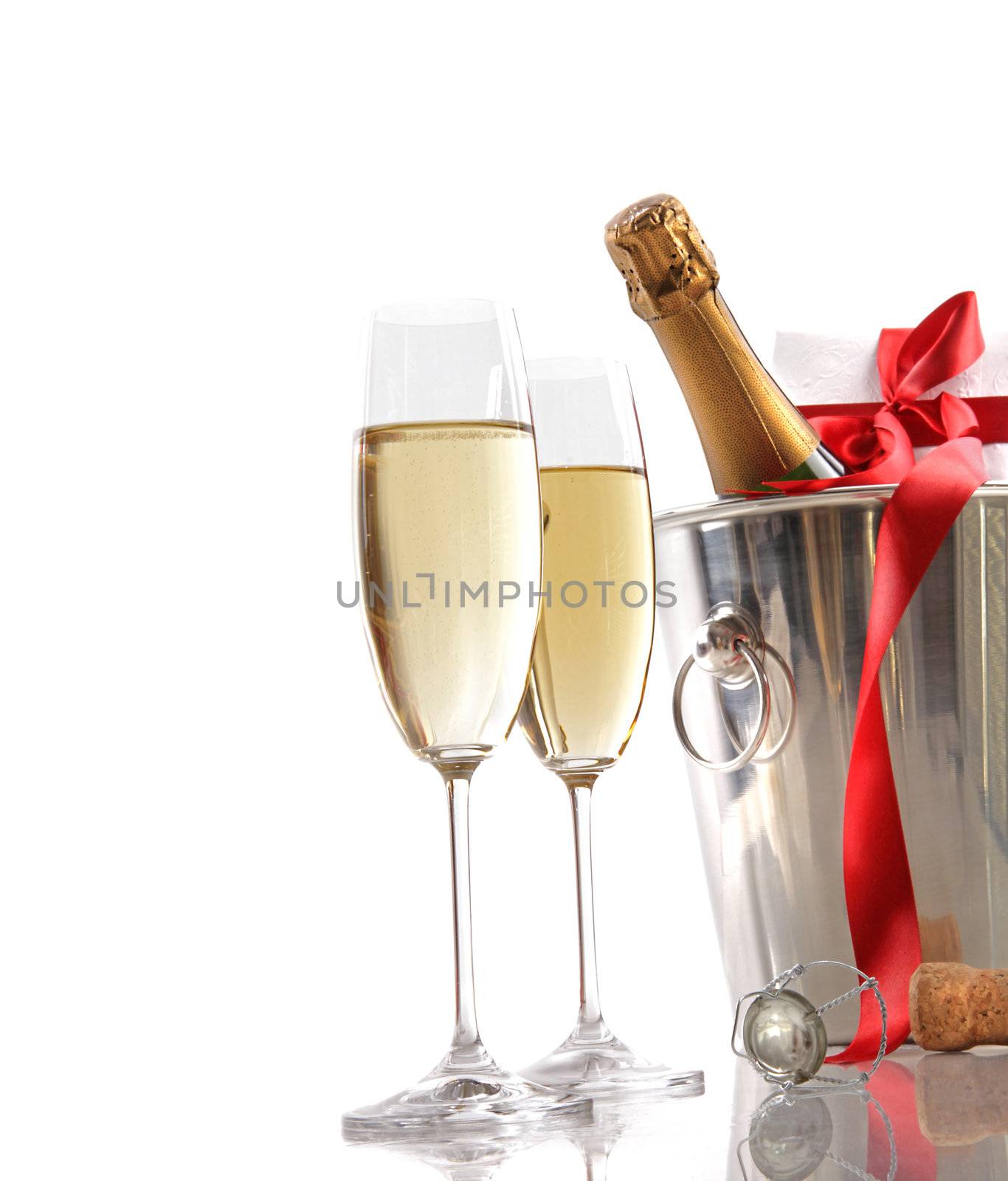 Glasses of champagne and ice bucket with red ribbon gift