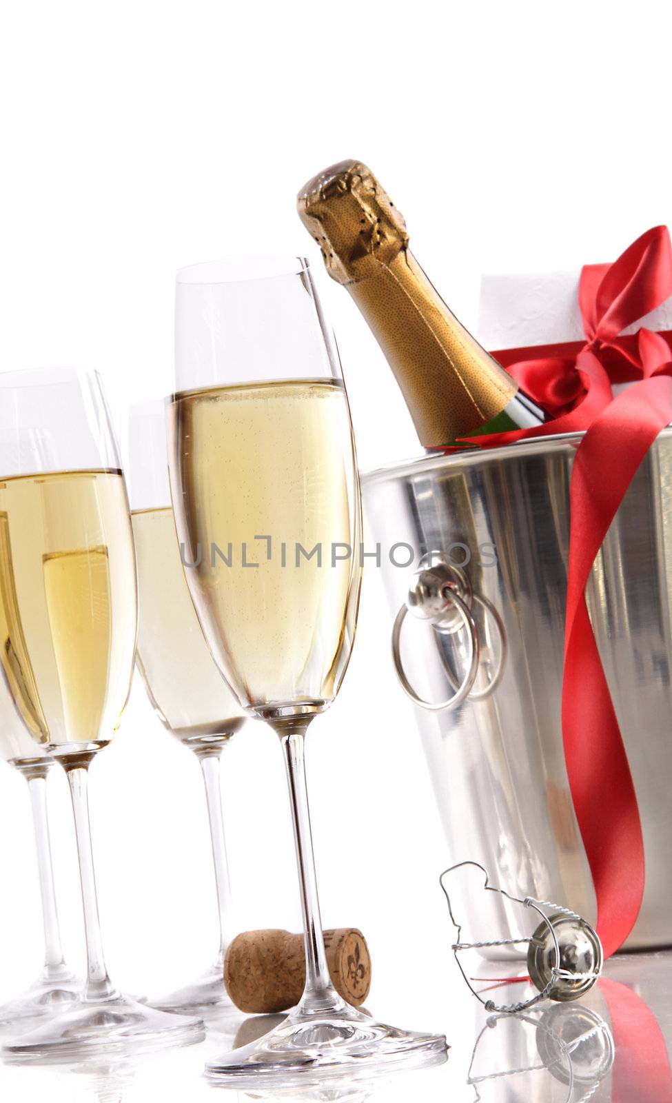 Glasses with Champagne in ice bucket and gift