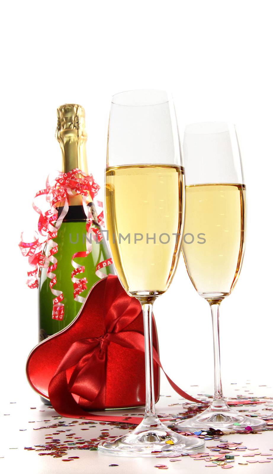 Glasses of champagne with red ribbon heart on white