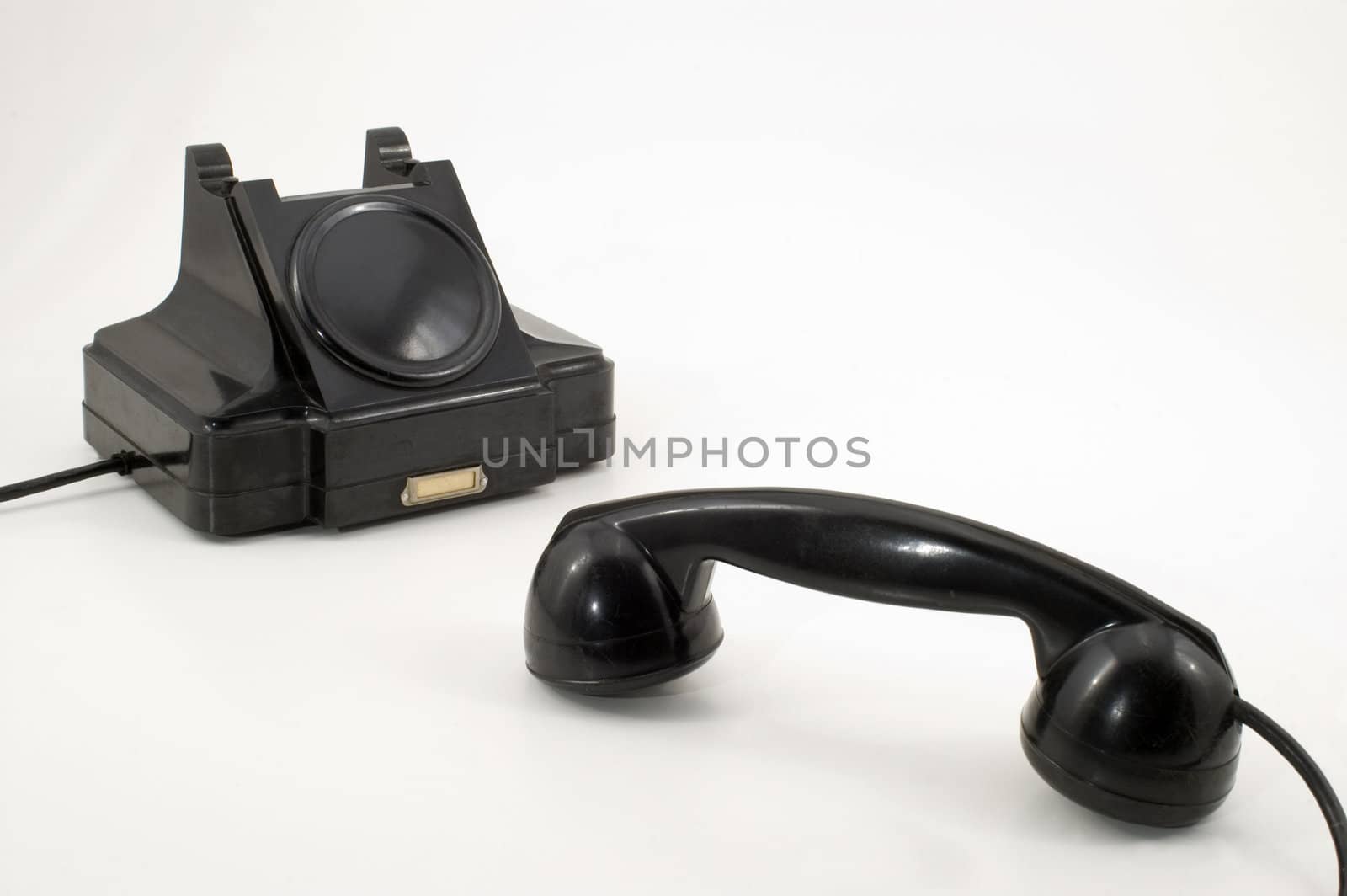 The old telephone of black colour on a white background.
