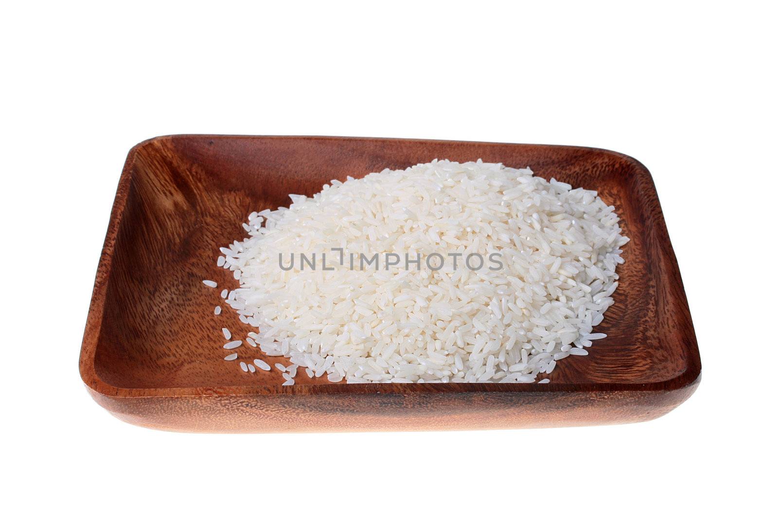 Rice grains in a wooden plate on a white background.