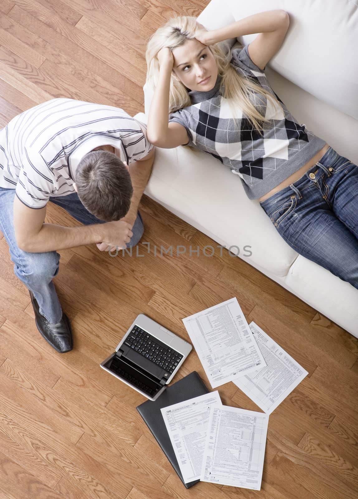 High angle view of a young couple frustrated while doing paperwork. Vertical shot.