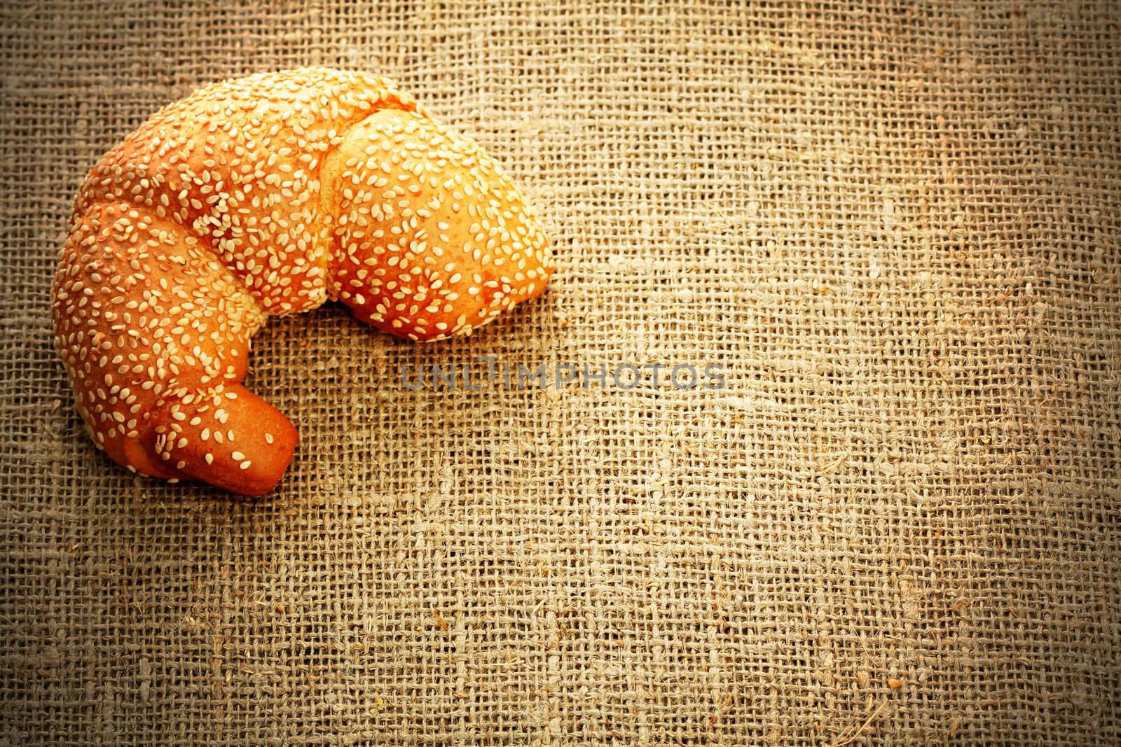 Croissant with sesame on a sacking background