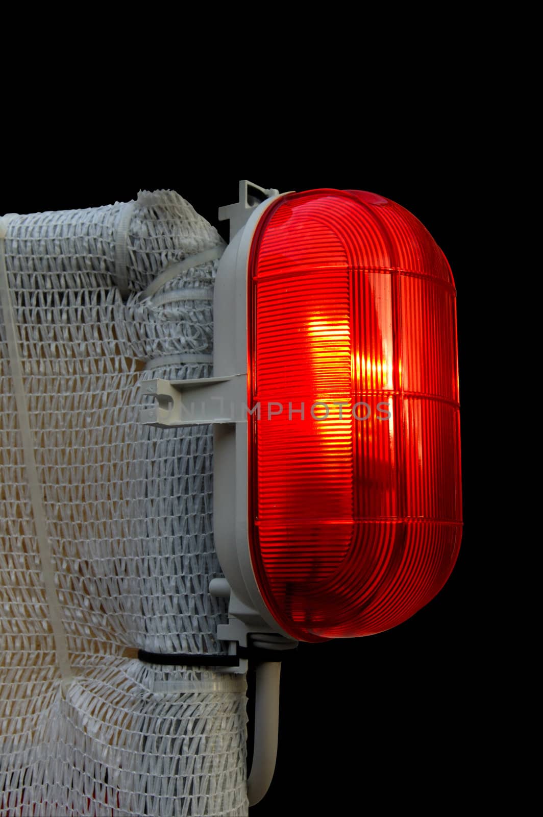 A red warning lamp, illuminated, set against a black background. Space for text on the background.