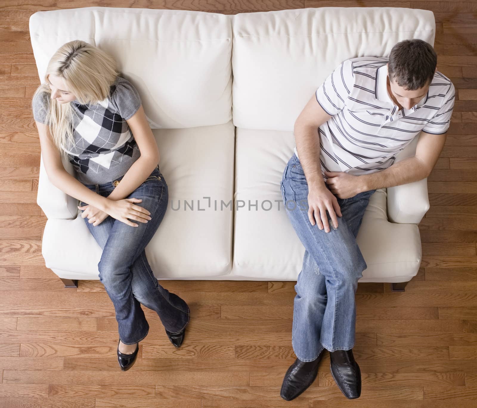 Young Couple Sitting on Love Seat by cardmaverick