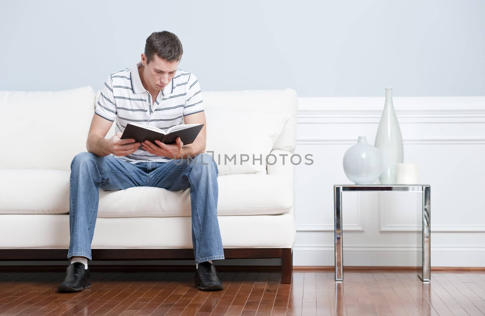 Man Reading on Living Room Couch by cardmaverick