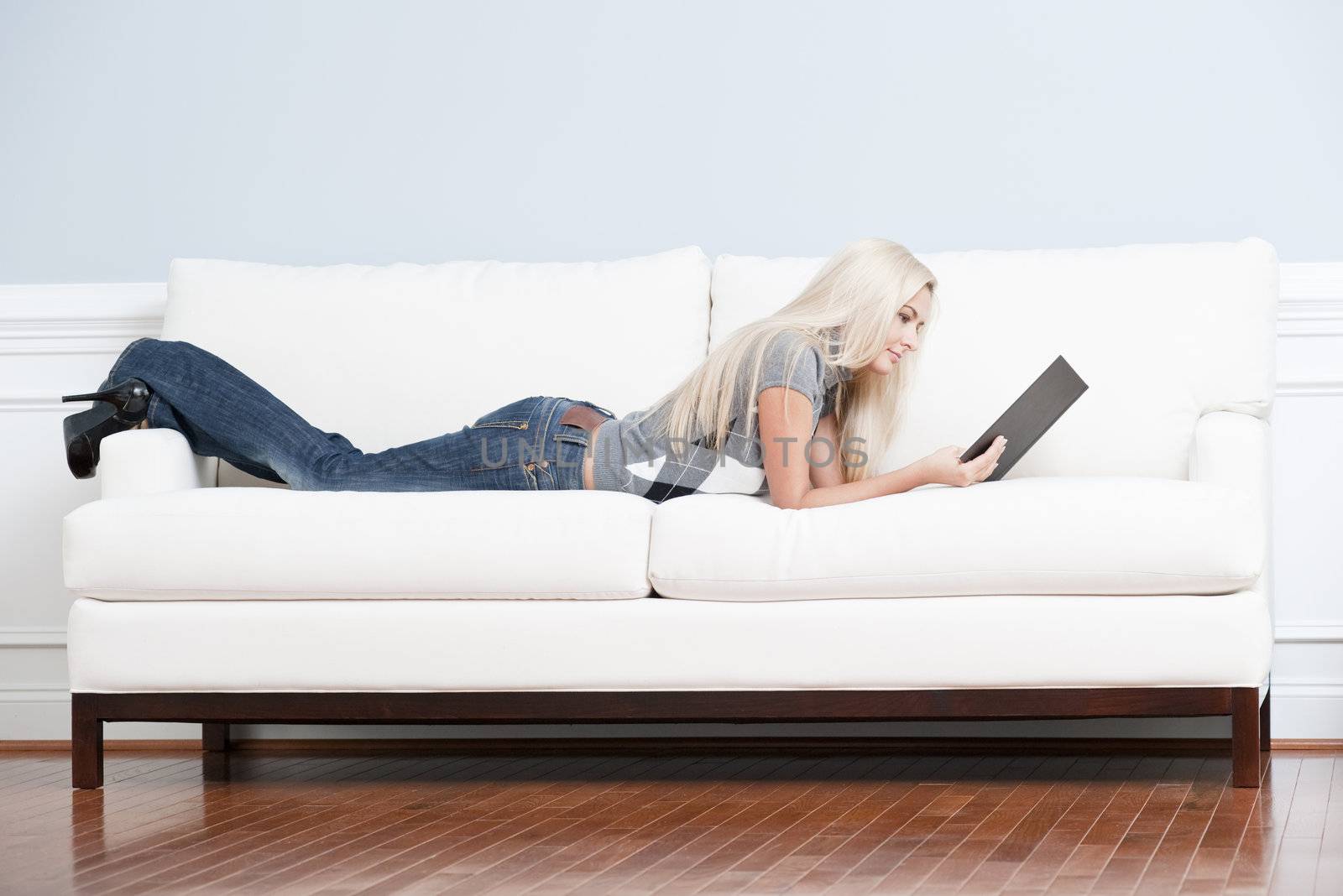 Woman Reclining on Couch With Book by cardmaverick