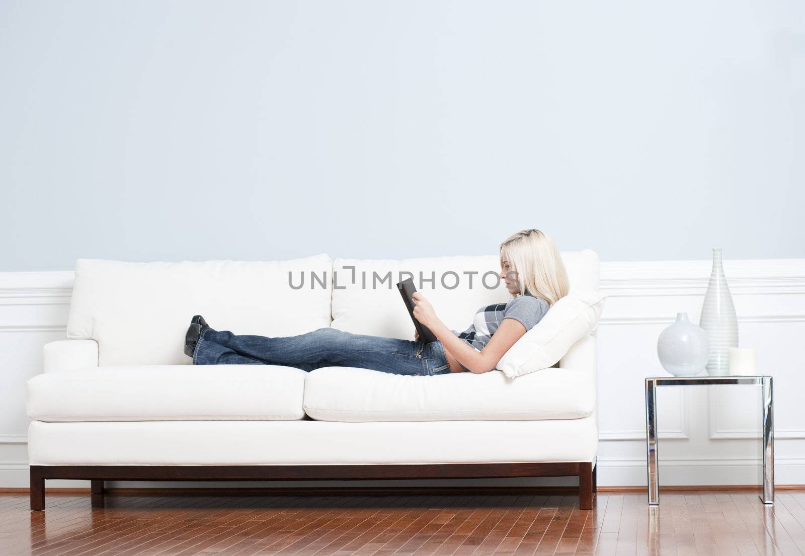 Woman Reclining on Couch With Book by cardmaverick