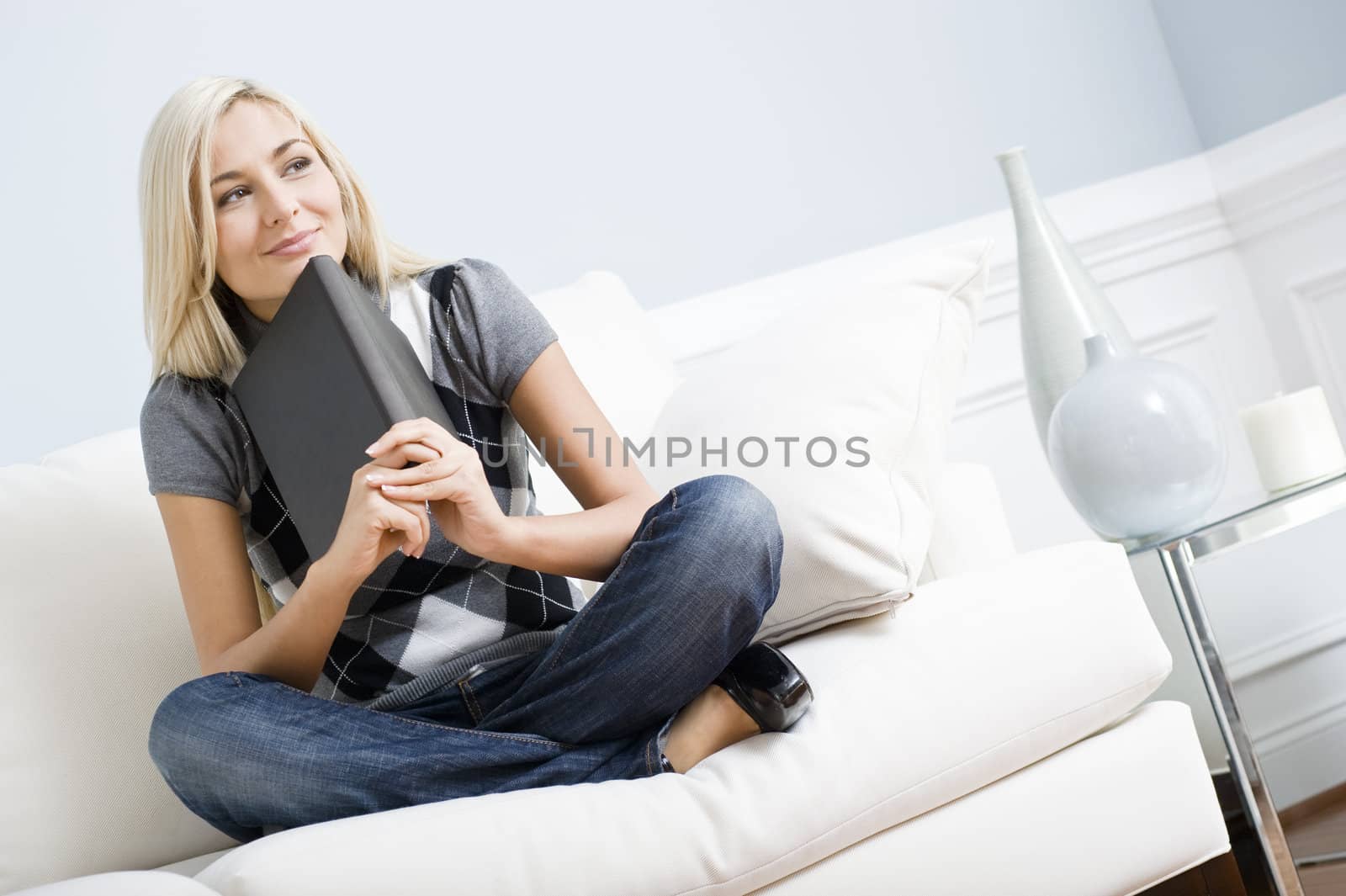 Smiling Woman Sitting on Couch and Holding a Book by cardmaverick