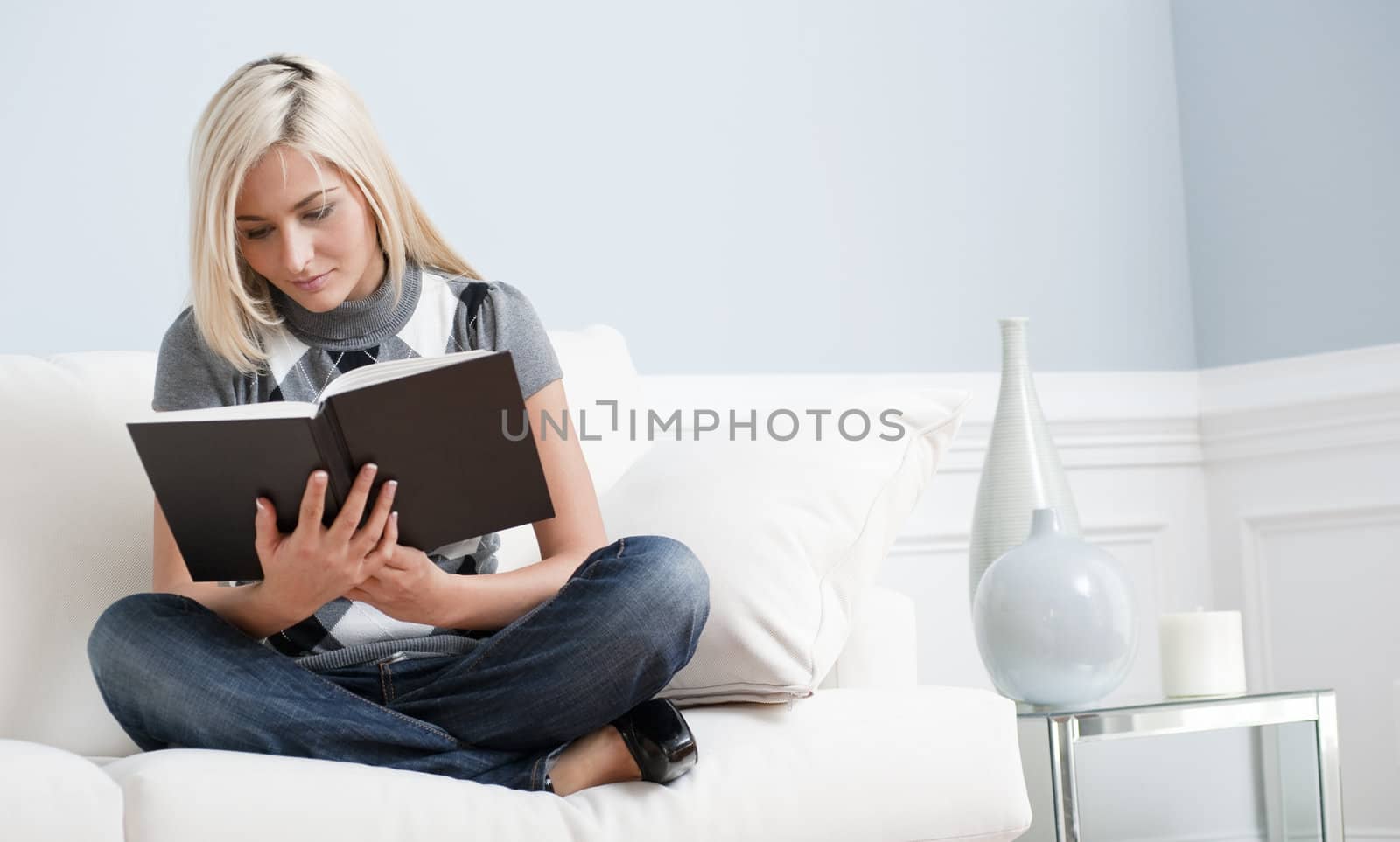 Woman Sitting on Couch and Reading a Book by cardmaverick