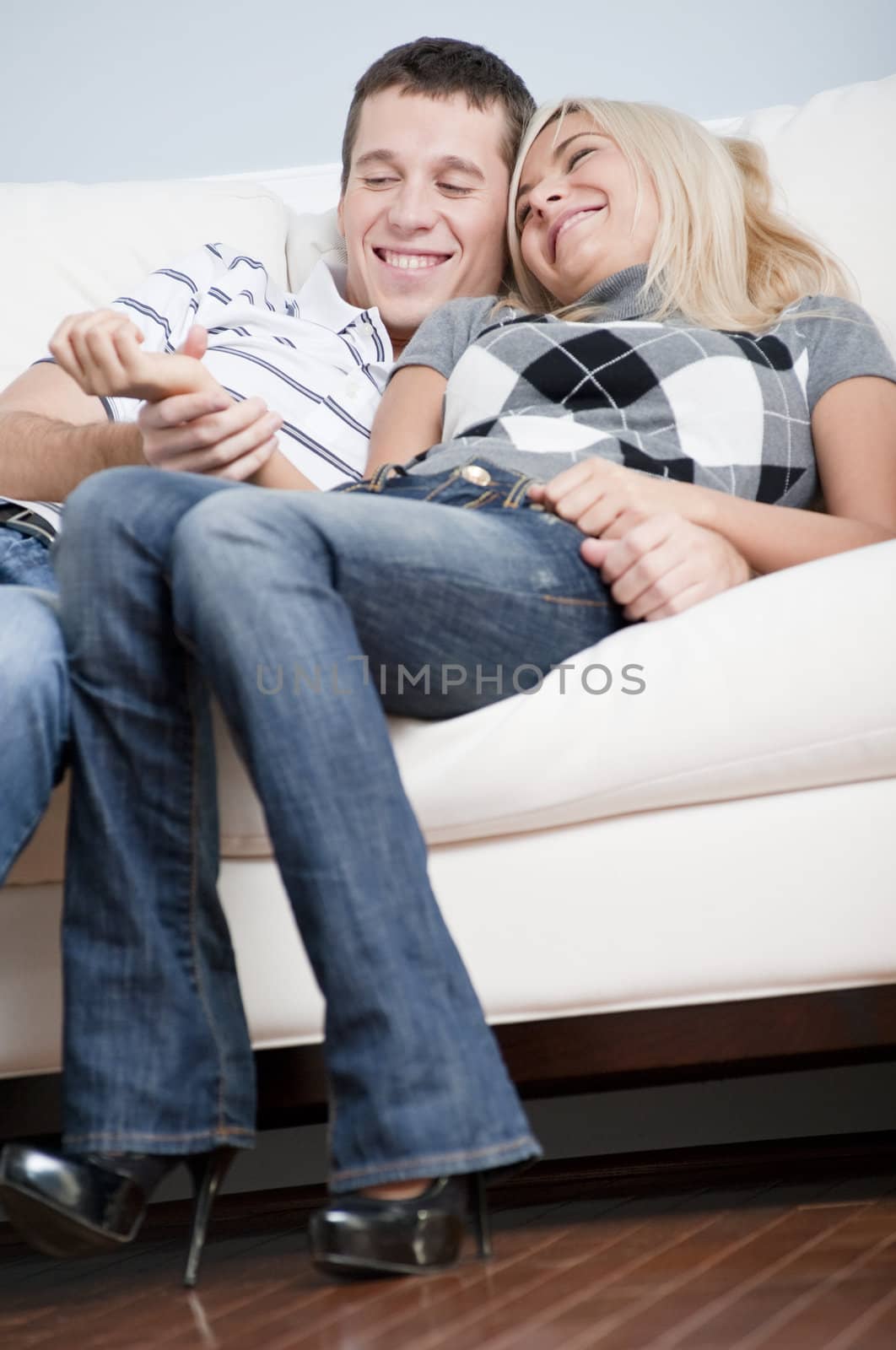 Affectionate Couple Laughing and Relaxing on Couch by cardmaverick