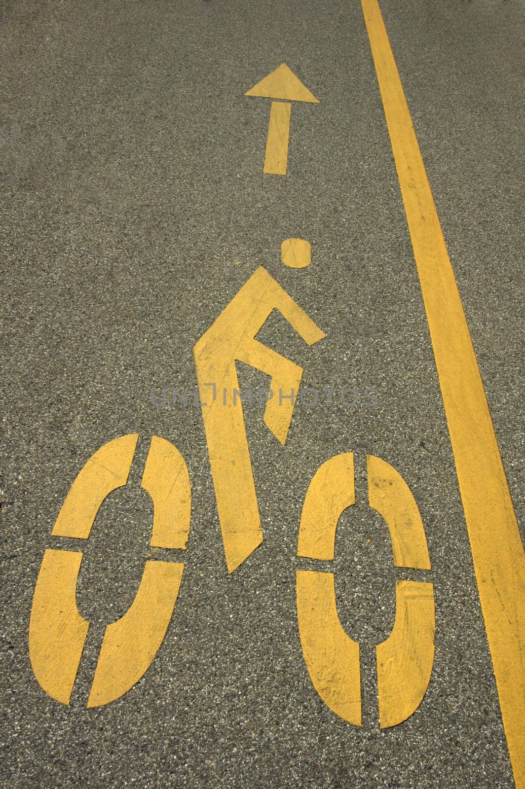 A cycle-track sign with arrow. Space for text on the tarmac to the left of the arrow.