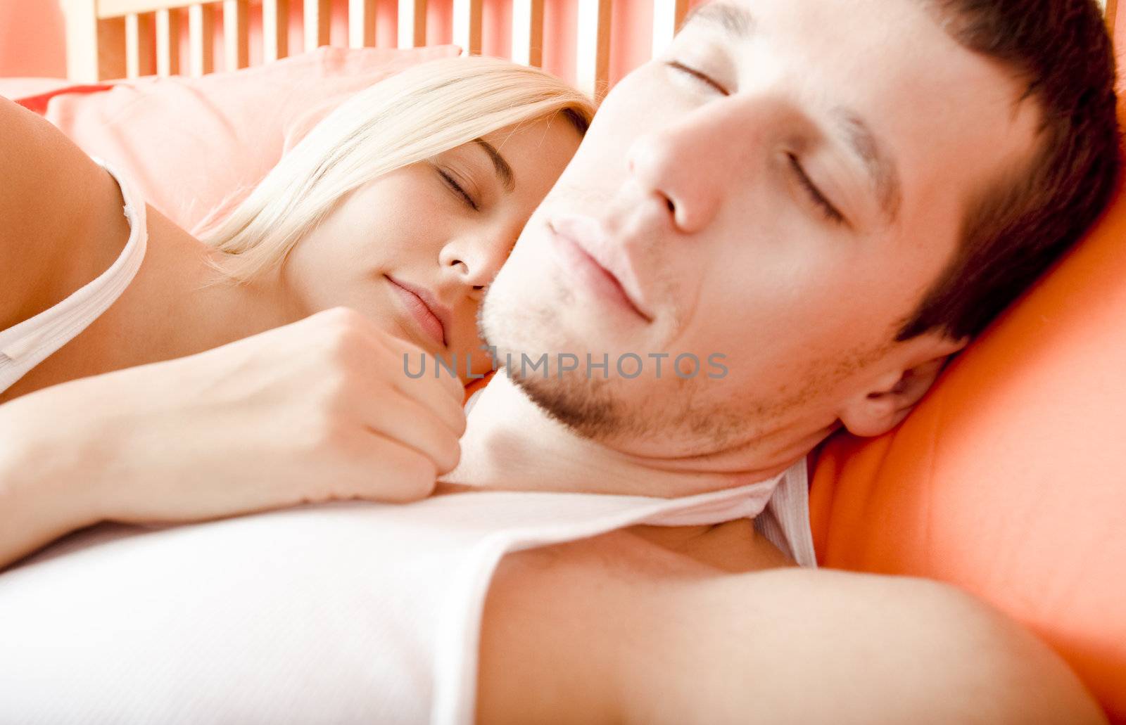 Cropped close-up of man and woman sleeping close together in bed. Horizontal format.