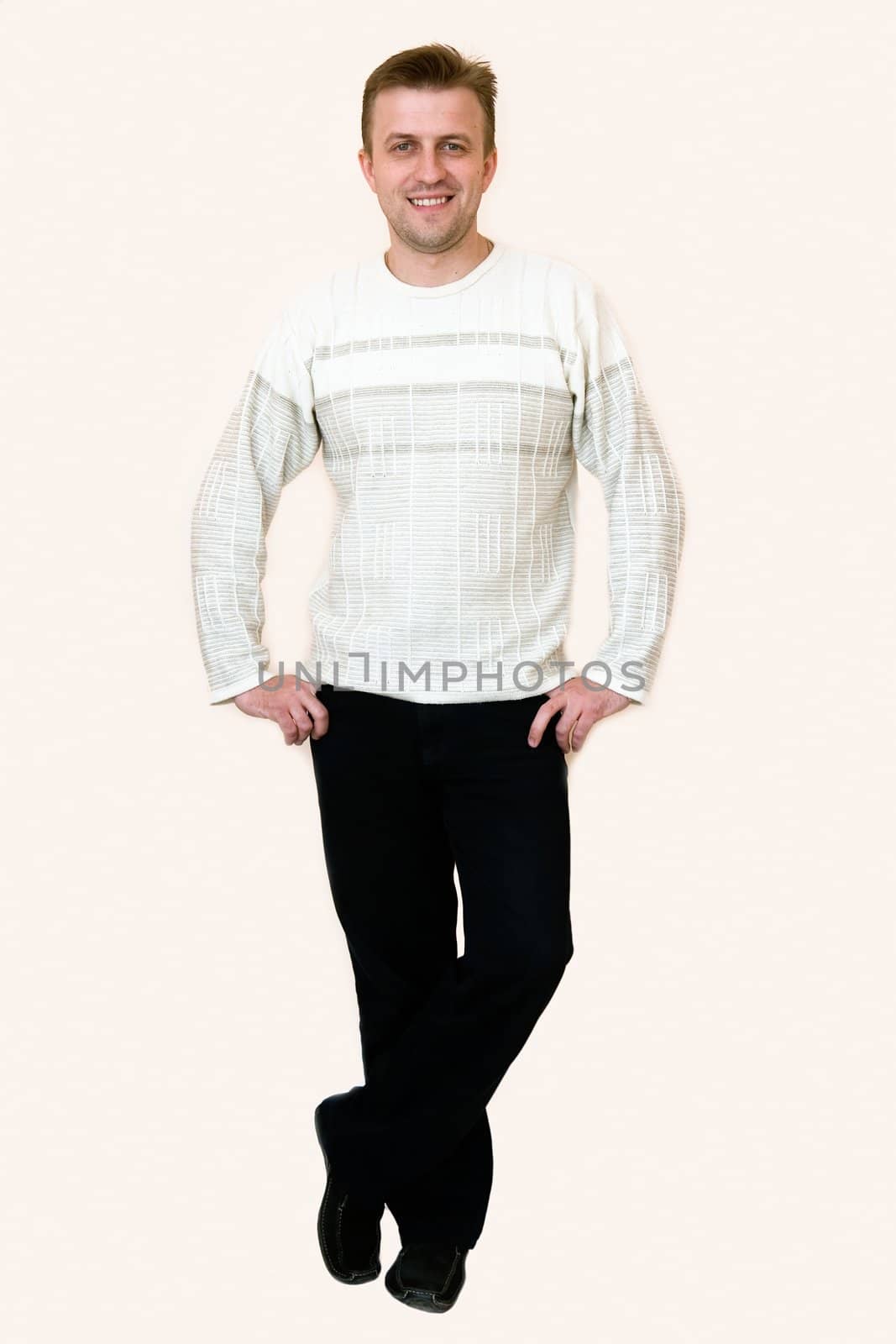 The smiling young man stands. Full-length portrait.
