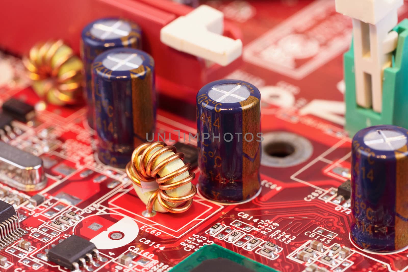 Close up of electronic components on a red circuit surface