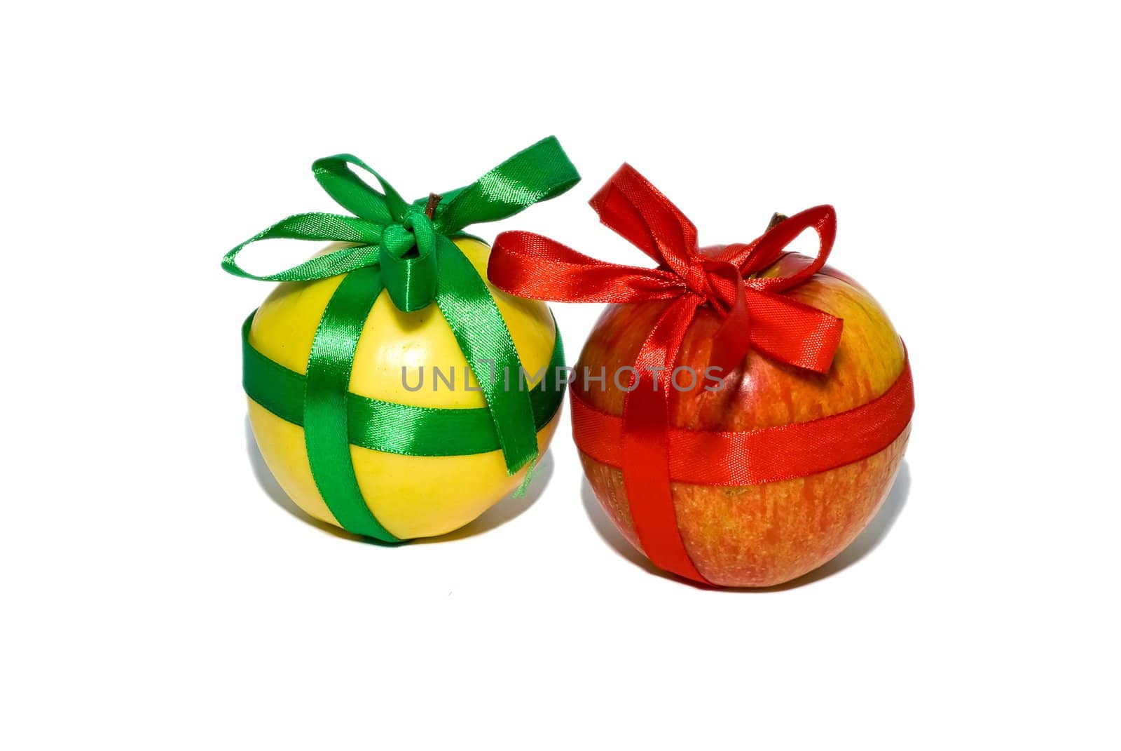 couple of red and yellow apples with a gift bows on a white background
