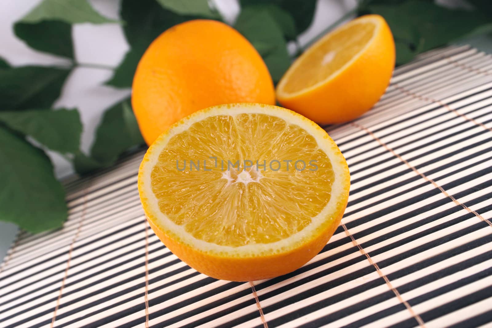 The cut orange on a bamboo napkin removed close up