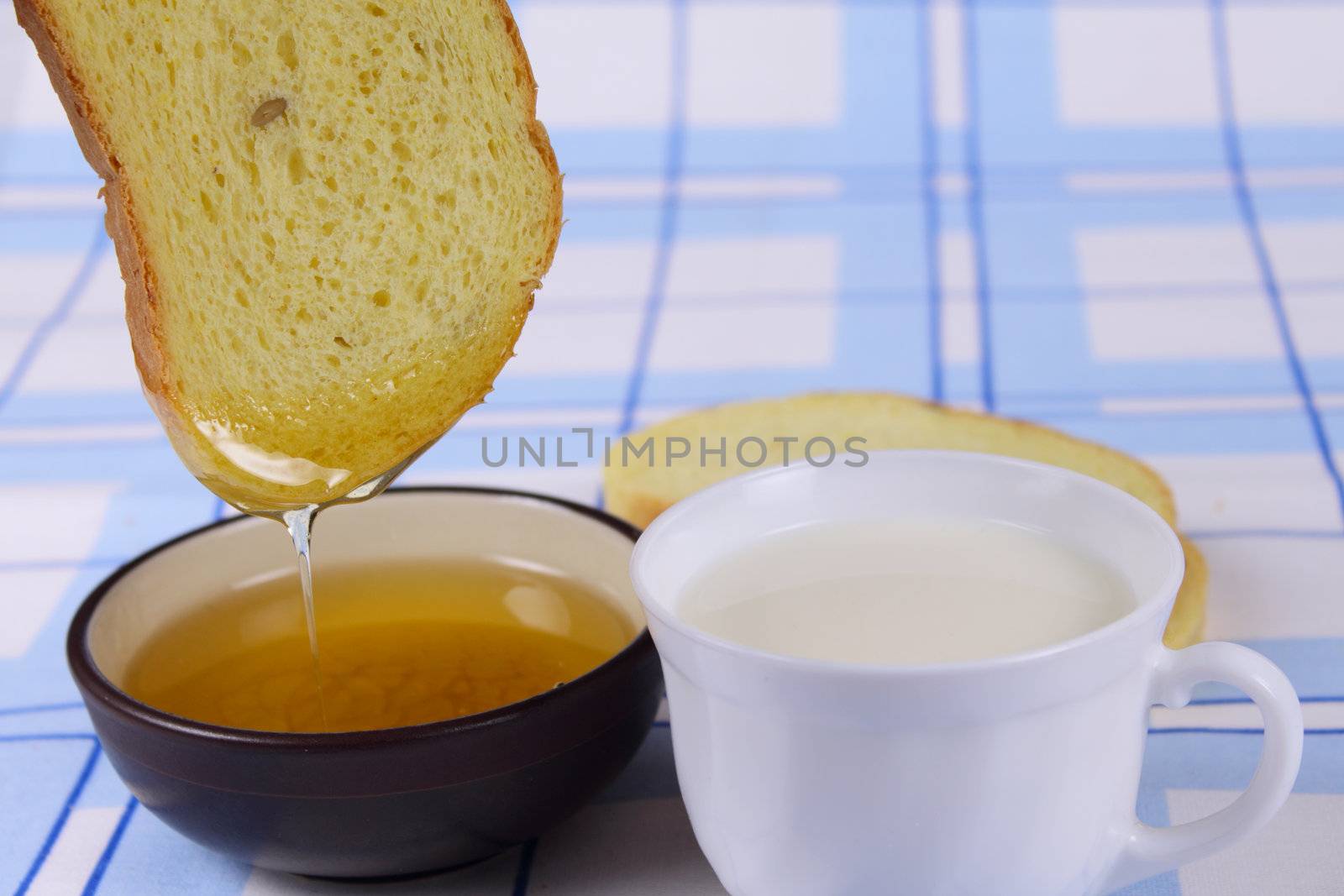 Cornbread with honey and milk on a linen blue napkin removed close up
