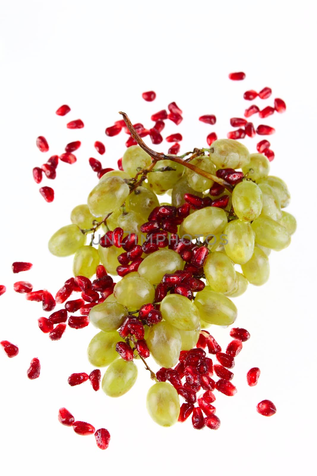 Cluster of grapes and pomegranate grain removed close up