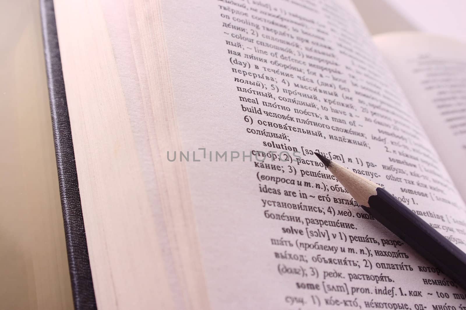 Graphic pencil lying on the dictionary removed close up