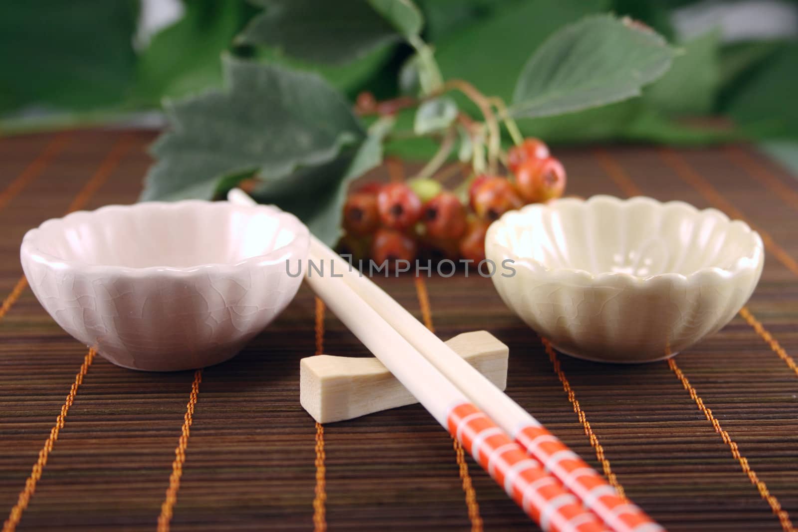 Chopsticks with two drinking bowl on a bamboo napkin