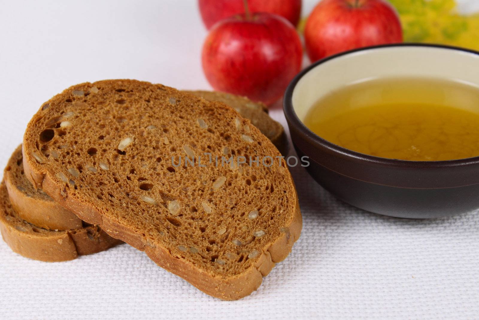 Honey with black bread and red apples on a linen white napkin