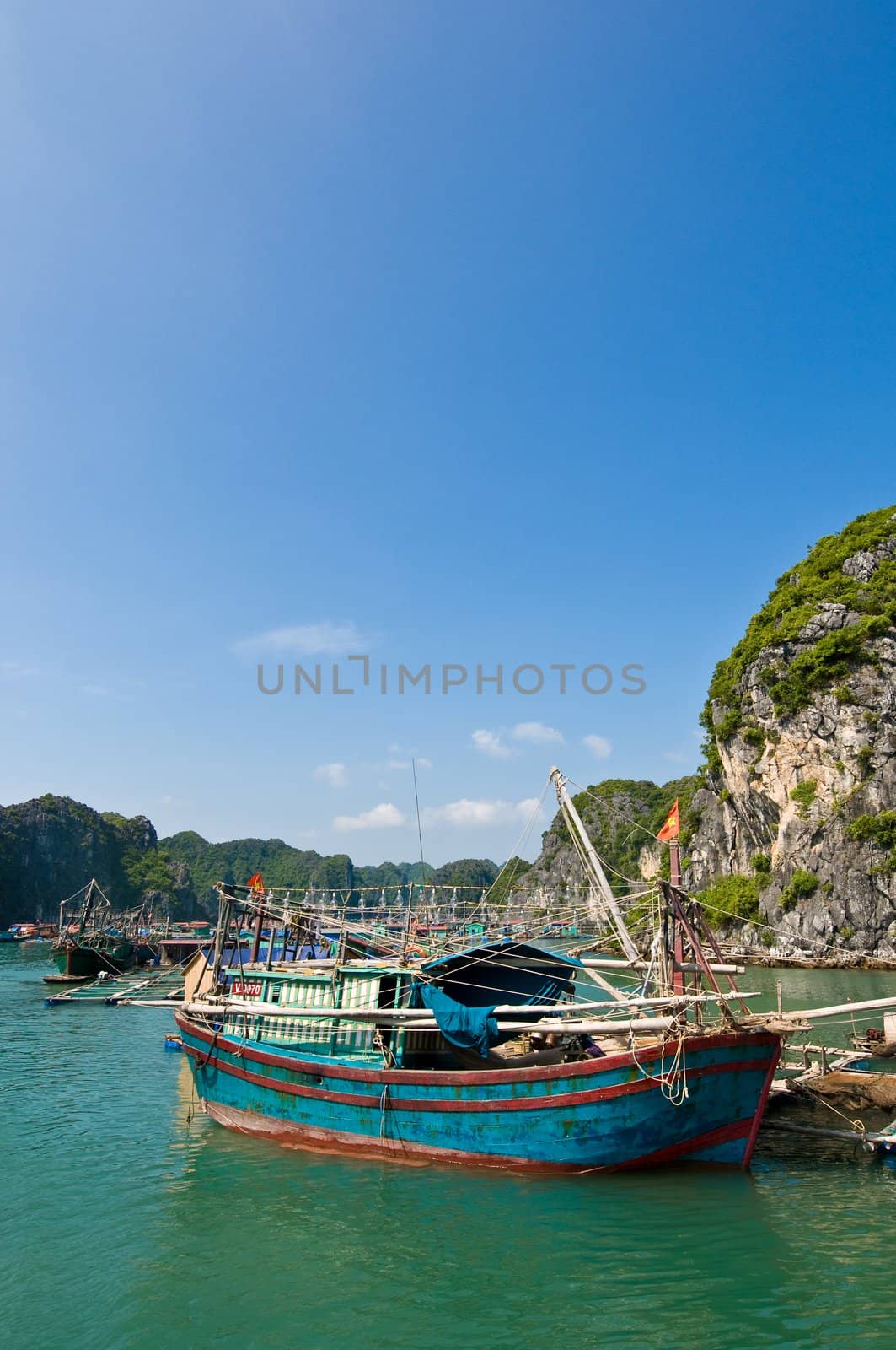 Wooden boat near one of the many fish farms located at Ha Long Bay.