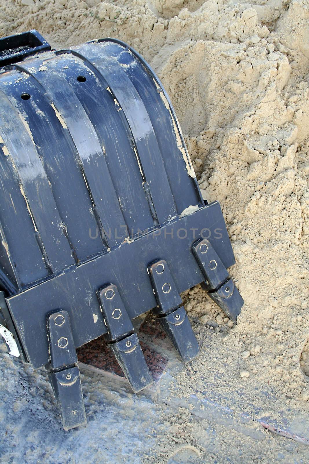 Black metal shovel bucket near to a heap of sand, (look similar images in my portfolio)