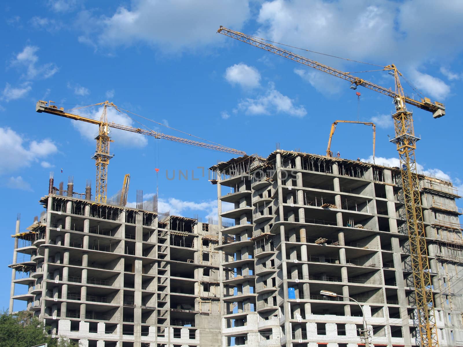 Two elevating cranes of yellow color on a construction site in Volgograd, (look similar images in my portfolio)