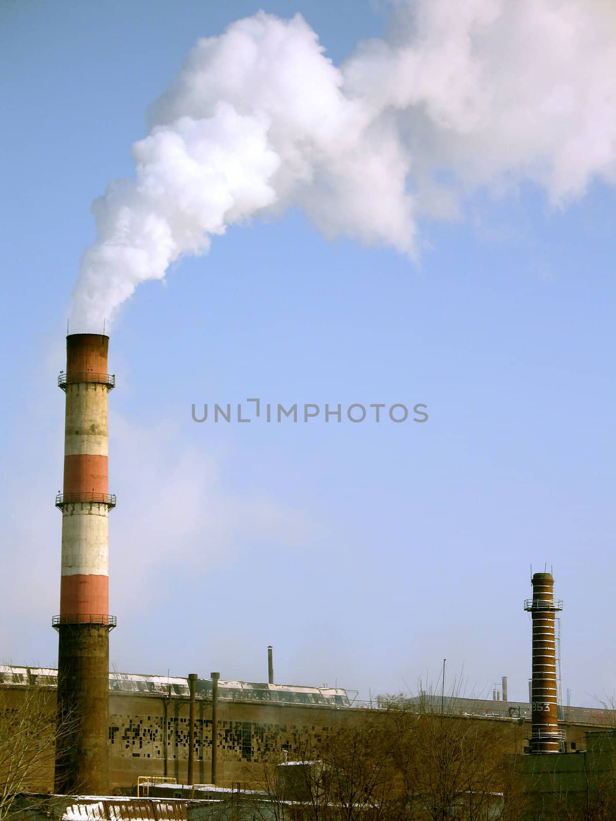 Department of a metallurgical plant with smoking funnels on a background of the blue sky, (look similar images in my portfolio)