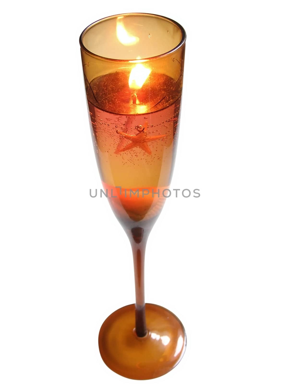 Candle in wineglass with sea star and shells