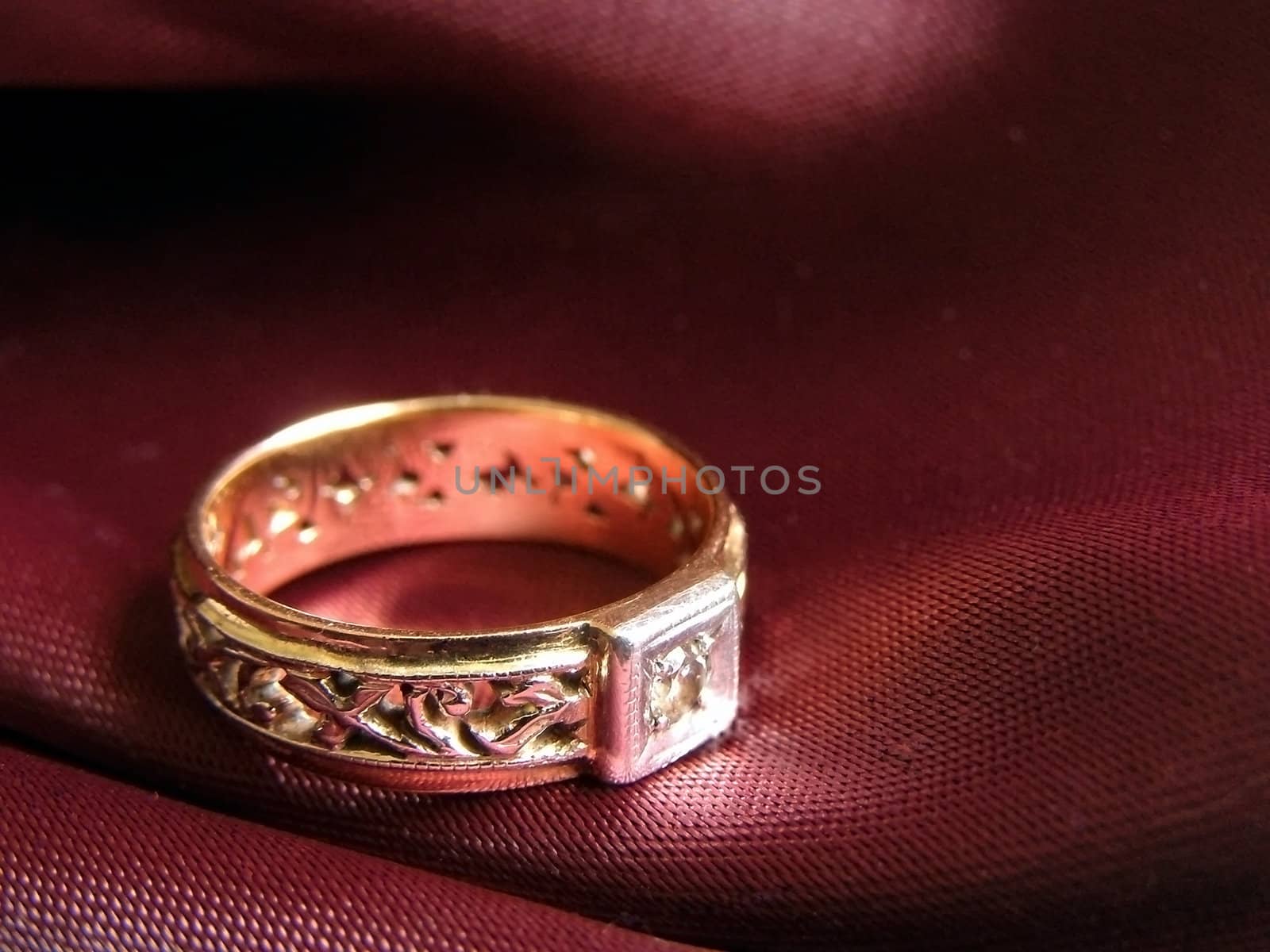 golden ring on the red against dark background