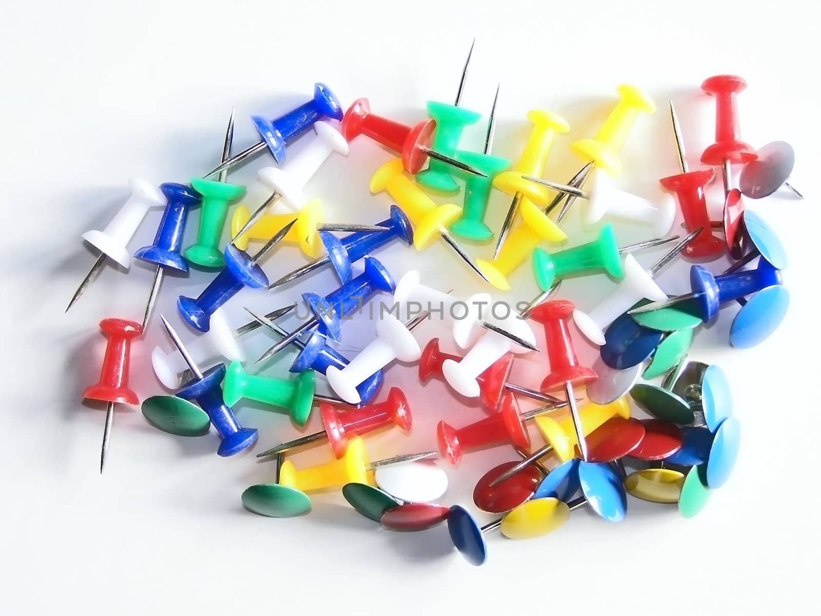 scattered multicolored thumb tacks and pins