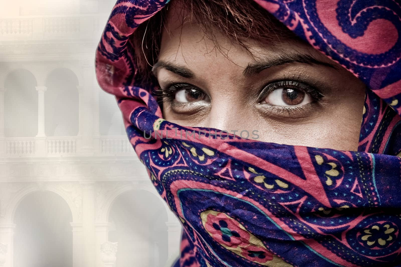 An attractive middle eastern woman wearing a colorful head covering.