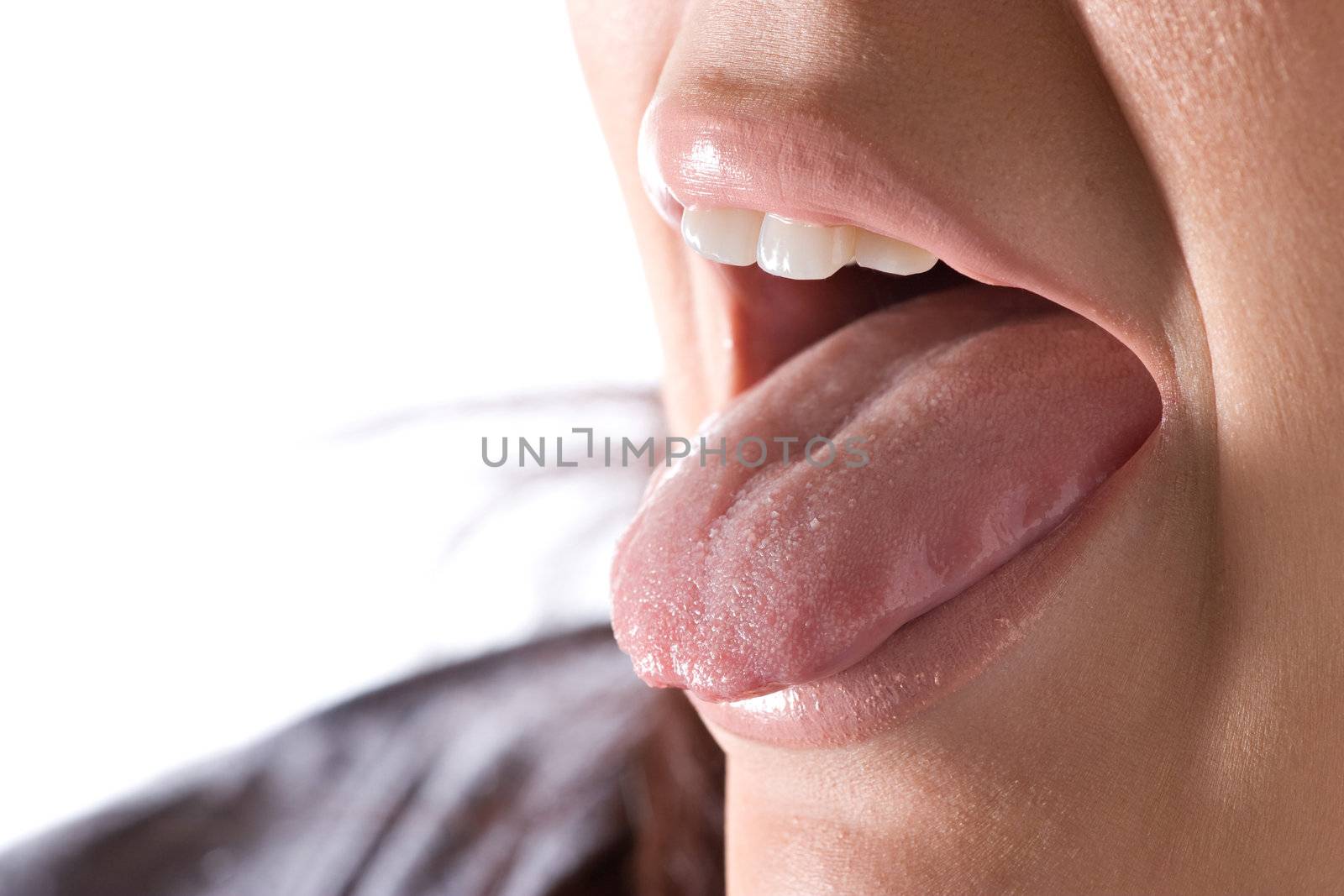 Closeup of a young woman sticking out her tongue.