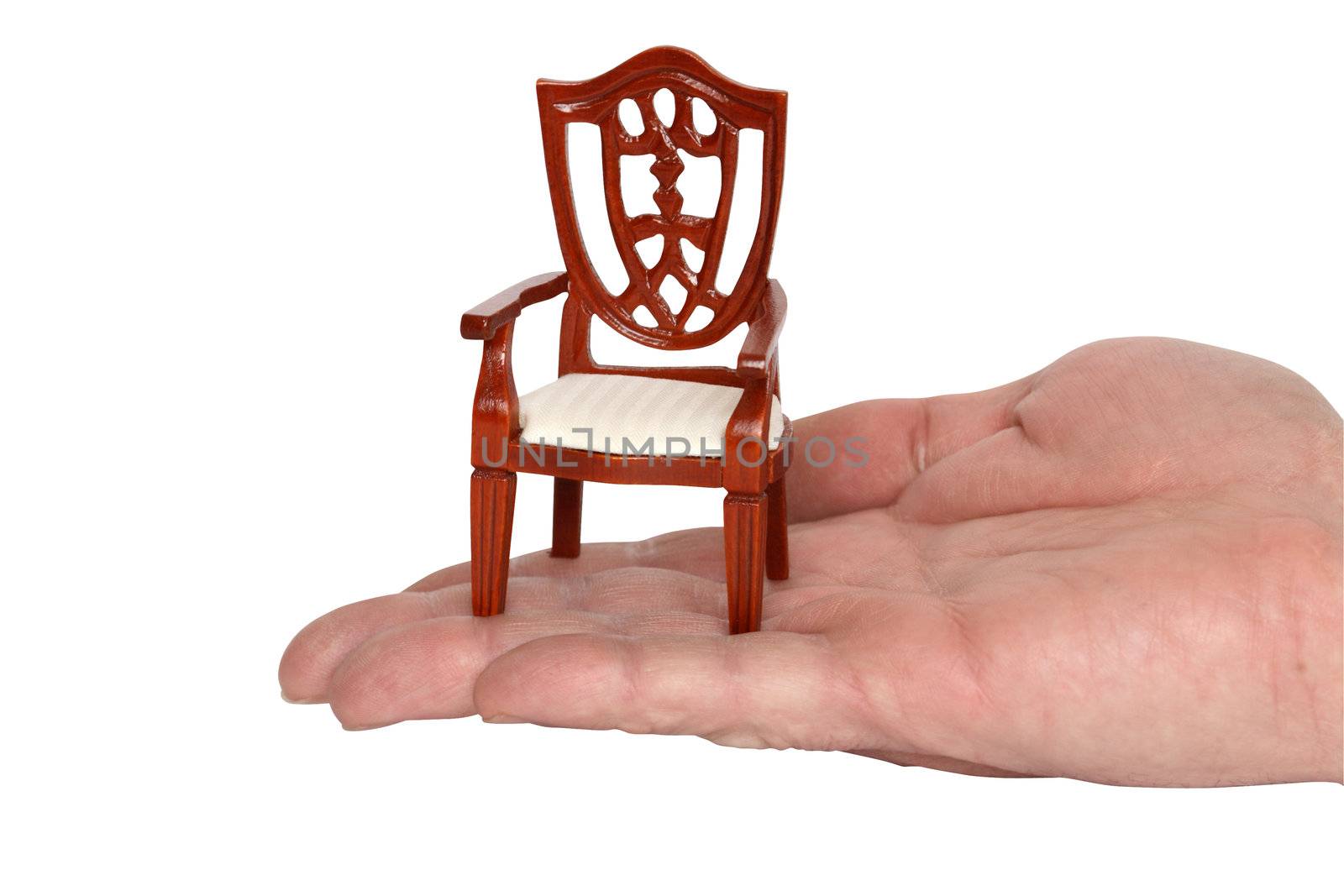 Miniature toy chair standing on human palm. Isolated with clipping path