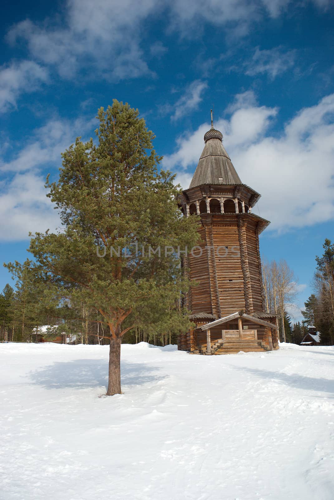 Wooden bell tower.Pines wood and blue sky