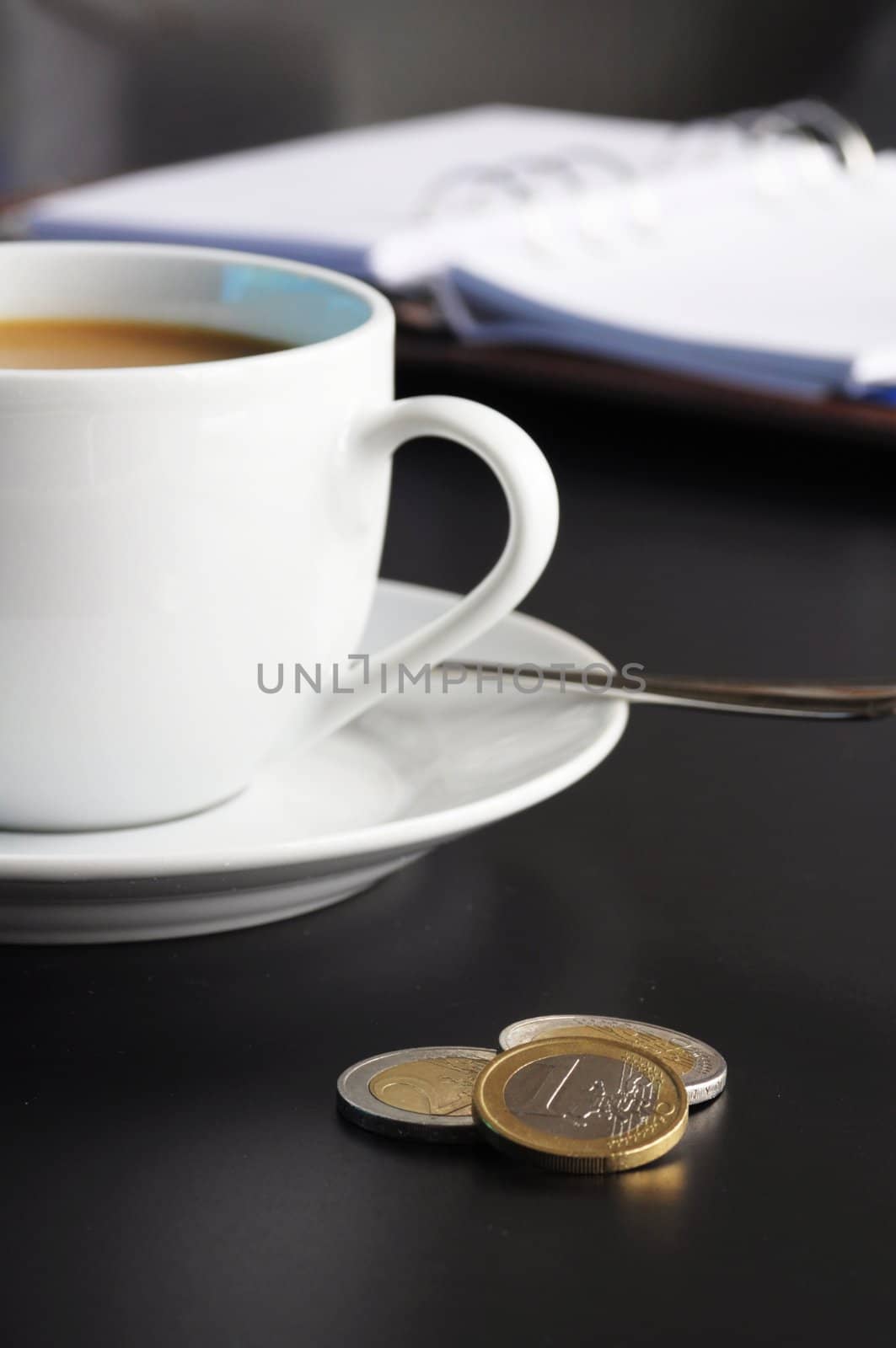 coffee and organizer in a black table showing break or breakfast in office