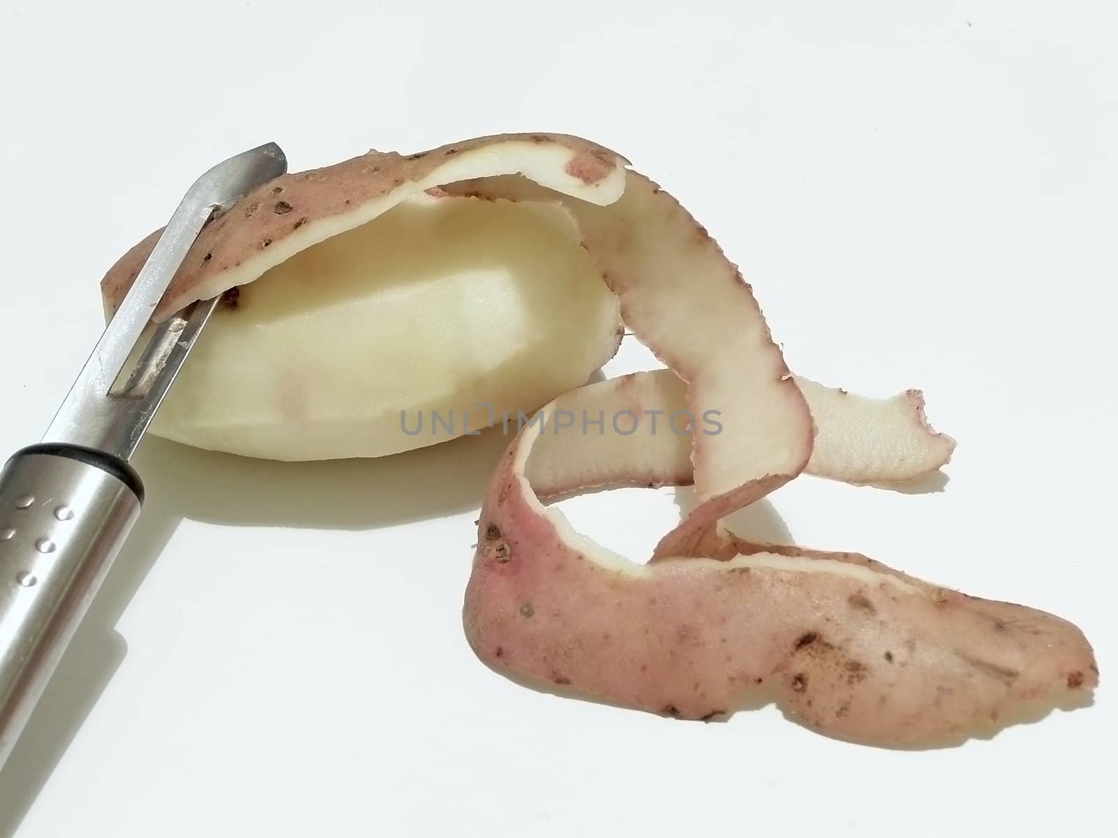 potato peeled on a half with potato knife     