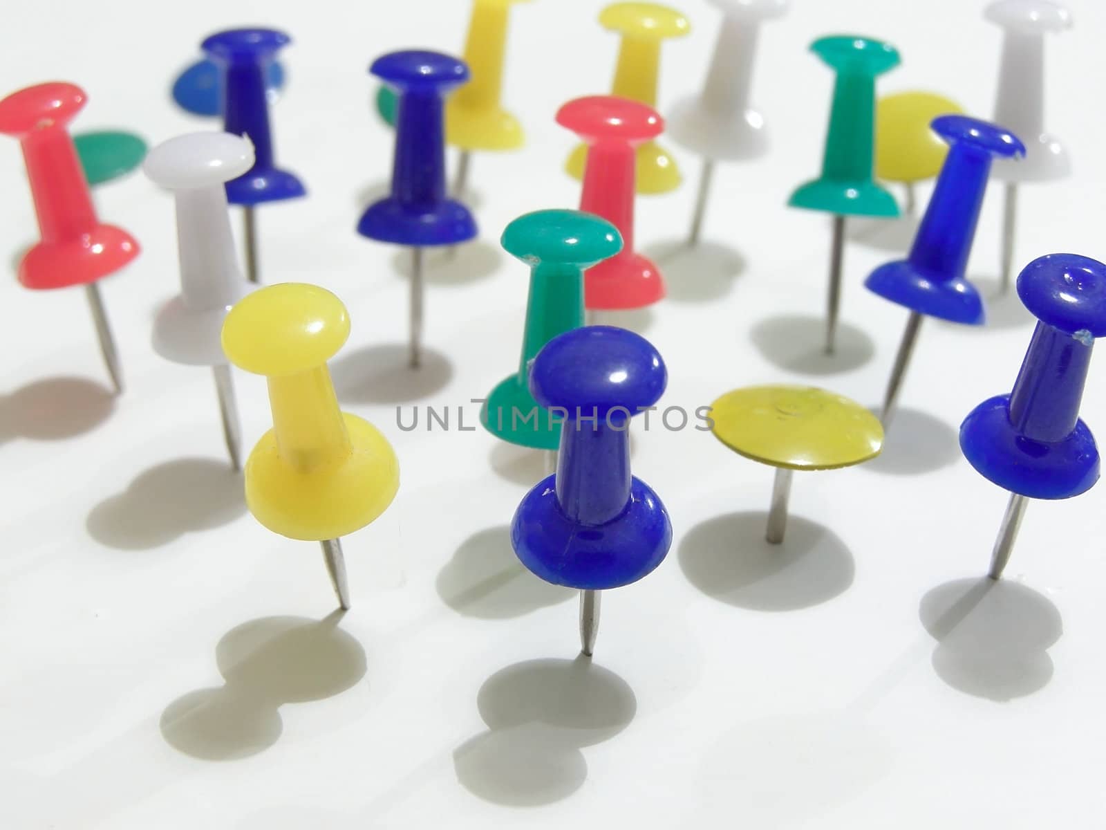 multicolored thumb tacks thrusted in to the table       