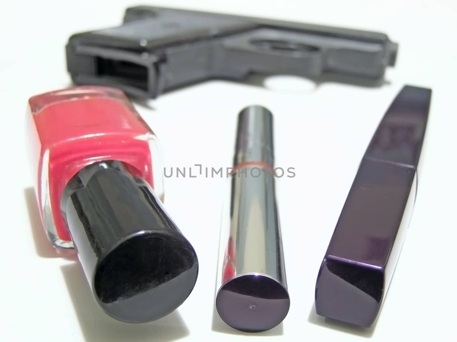 Woman cosmetic things and military gun on the background   