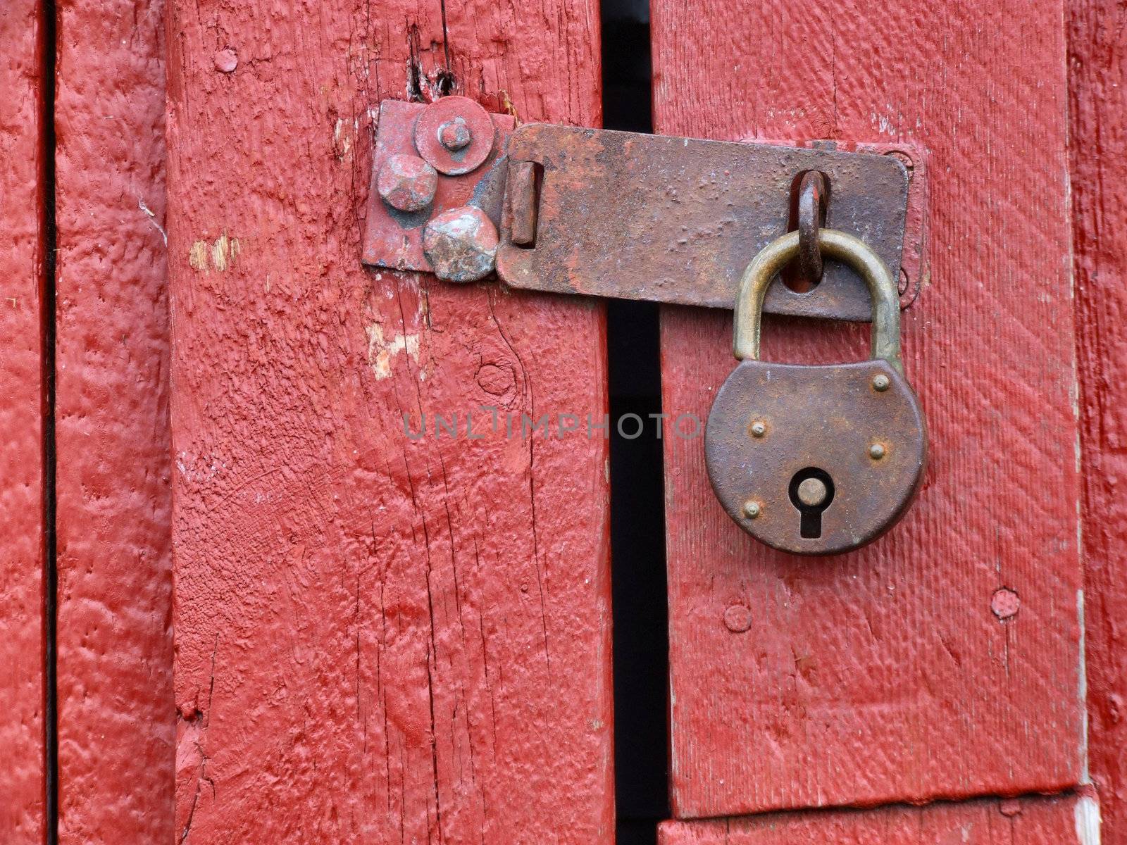 Old rusty padlock on a wooden door in Norway.